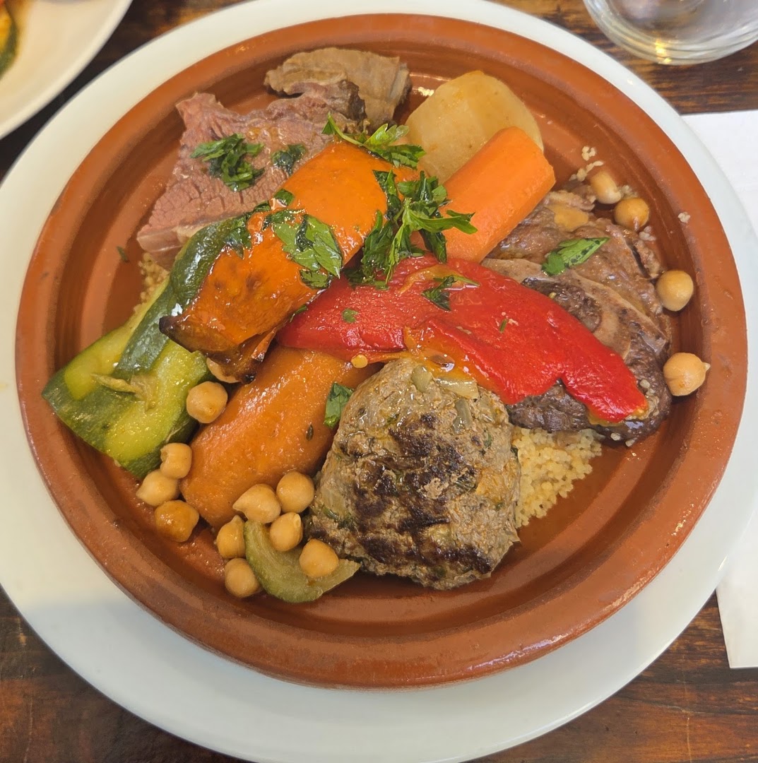 Plat en terre garni de viande, légumes, pois chiches et semoule