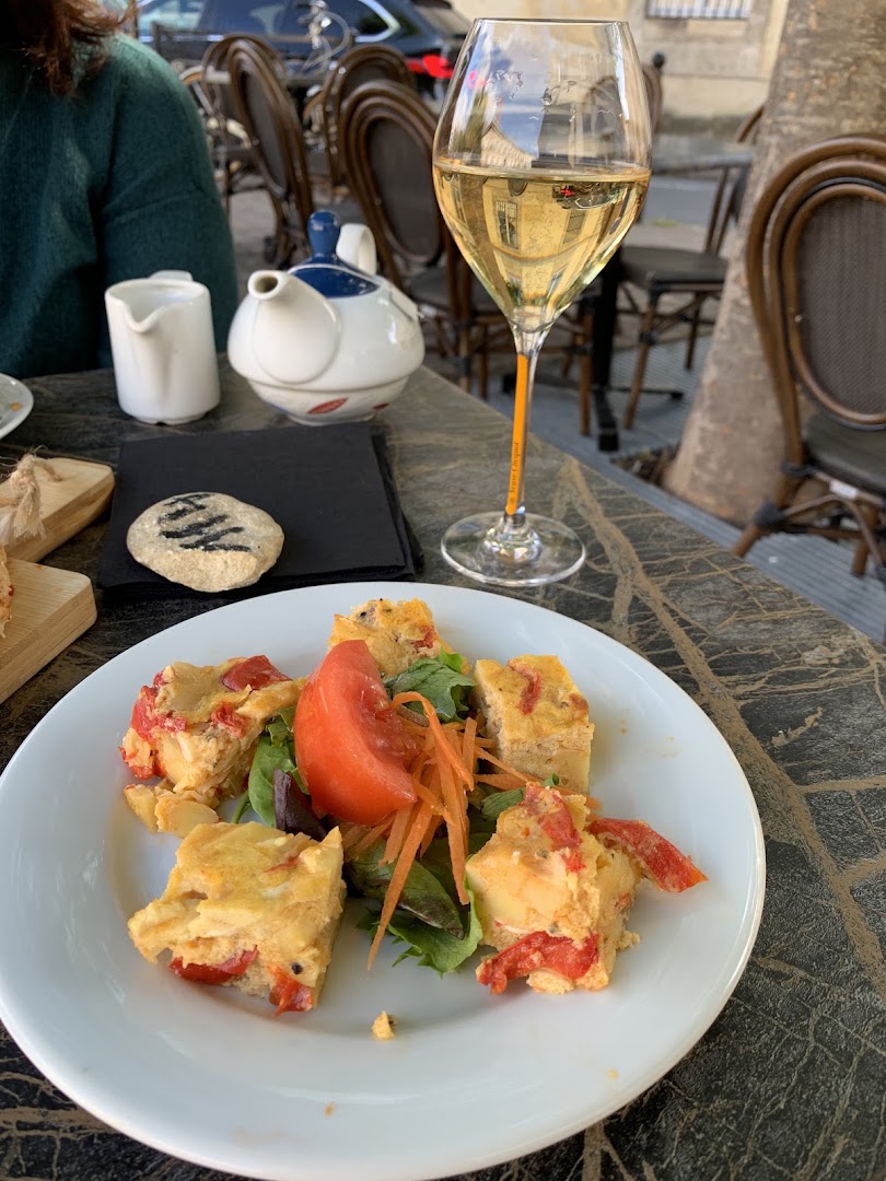 Assiette garnie, verre de vin blanc et service en terrasse